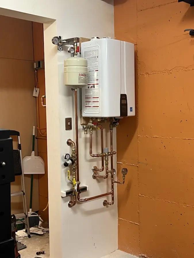 Plumbing technician inspecting water heater connections in Weddington